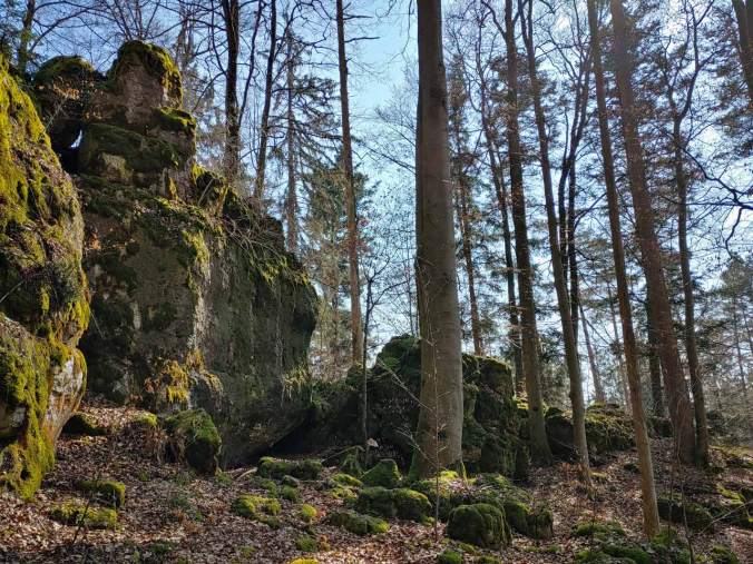 Moosbedeckte Felsen im Sonnenschein über der Fleischhöhle
