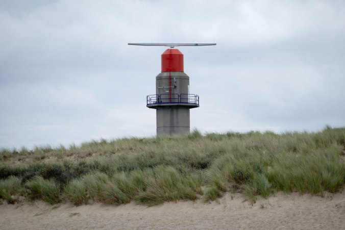 Die Spitze des Leuchtturms schaut über die Dünen