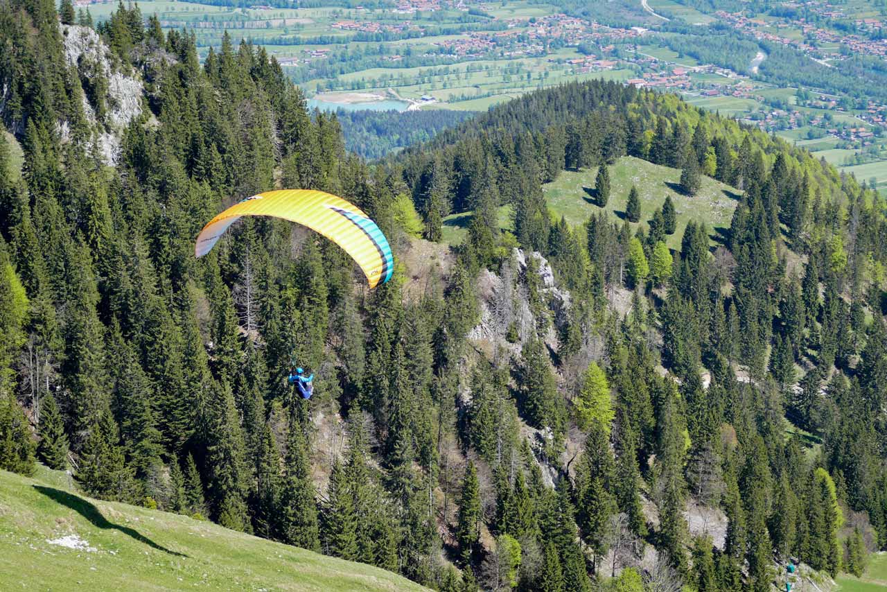 Ein Gleitschirmflieger startet an einem steilen Abhang