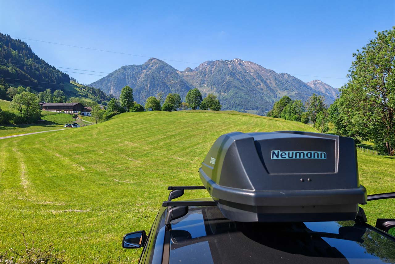 Im Vordergrund unser Auto samt Dachbox, im Hintergrund die Berge