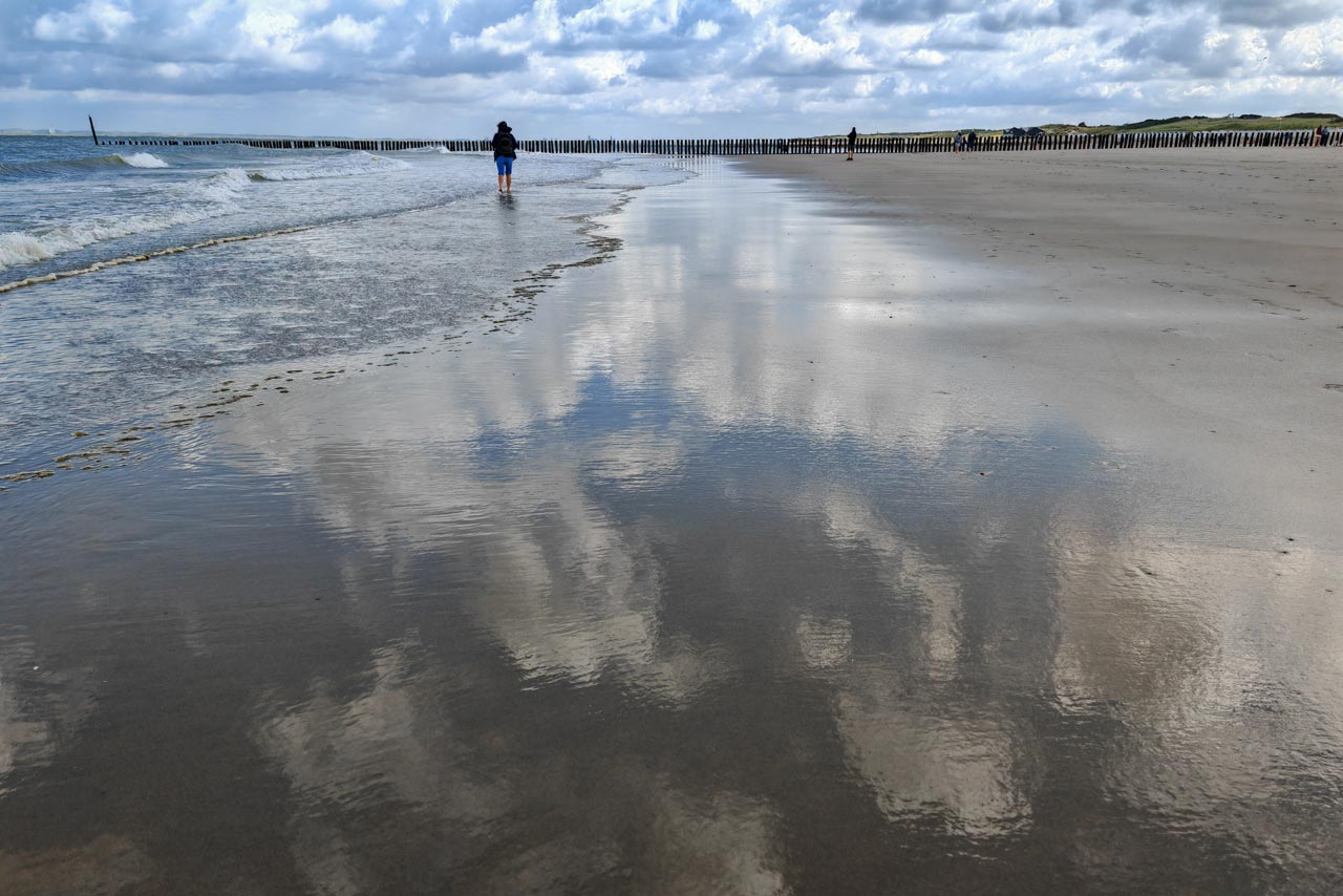 Die Spiegelungen am feuchten Strand haben etwas Besonderes